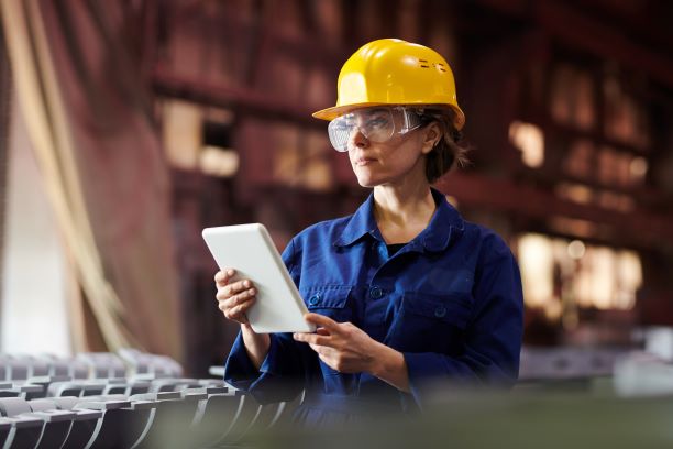 woman with yellow safety helmet and goggles on ipad